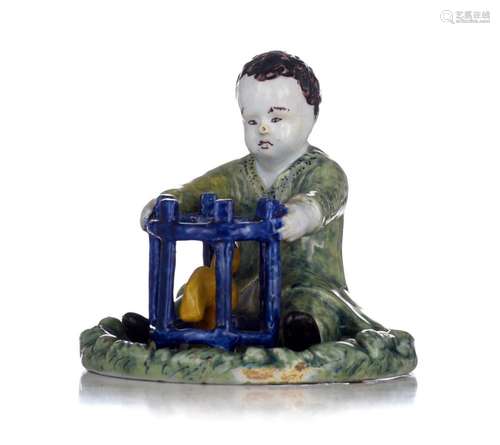 An exceptional Delft figure of a seated boy with a birdcage,...