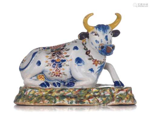 A Dutch Delft polychrome figure of a recumbent cow, 18thC, H...