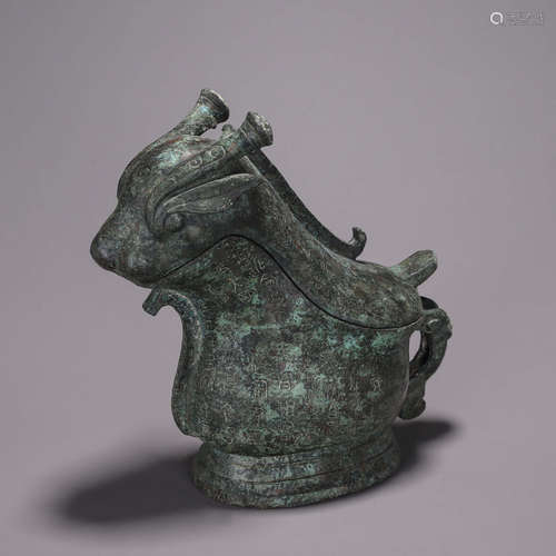 An inscribed bronze goat head pot