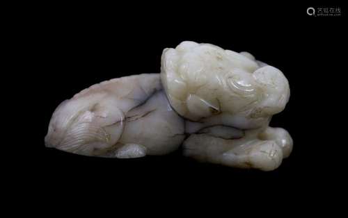 A Chinese Ming white and black jade figure of a recumbent be...