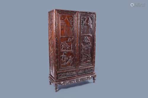 A CHINESE RICHLY CARVED WOOD TWO-DOOR CABINET WITH FIGURES I...