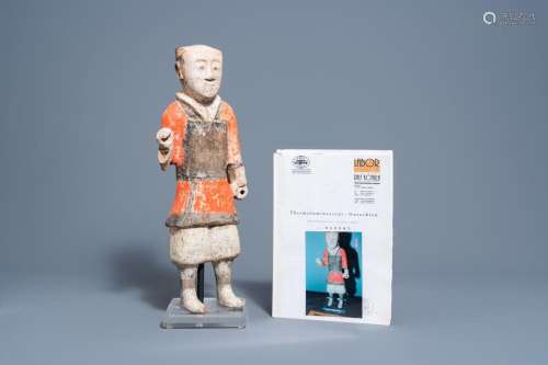 A CHINESE POLYCHROME PAINTED POTTERY FIGURE OF A STANDING AT...