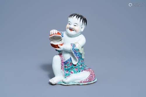 A CHINESE FAMILLE ROSE FIGURE OF A BOY HOLDING A BOX AND COV...