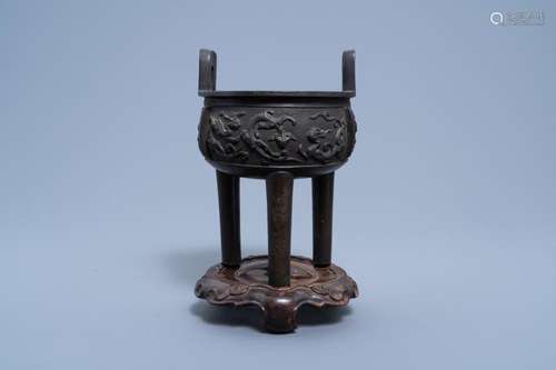 A CHINESE BRONZE TRIPOD CENSER ON WOODEN STAND, QING