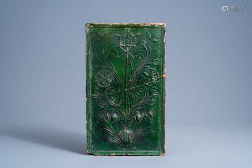 A GERMAN GREEN GLAZED EARTHENWARE STOVE TILE WITH FLORAL DES...