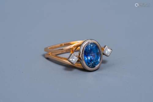 AN 18 CARAT YELLOW AND WHITE GOLD RING SET WITH A BLUE SAPPH...