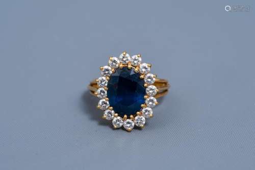 AN 18 CARAT YELLOW GOLD RING SET WITH A BLUE SAPPHIRE AND SI...