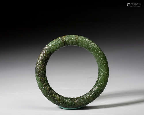 A CARVED SPINACH-GREEN JADE BANGLE,QING DYNASTY