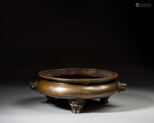 A BRONZE TRIPOD CENSER WITH LION-SHAPED HANDLES