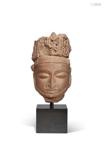 A RED SANDSTONE HEAD OF A DIVINITY