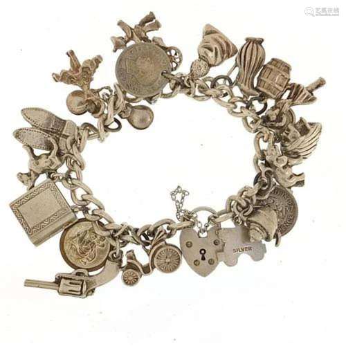 Silver charm bracelet with a selection of mostly silver char...