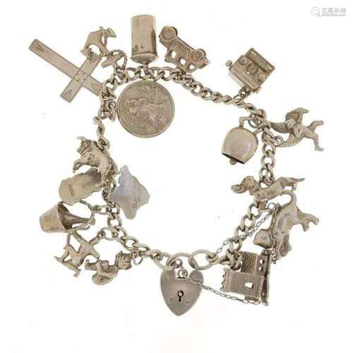 Silver charm bracelet with a selection of mostly silver char...