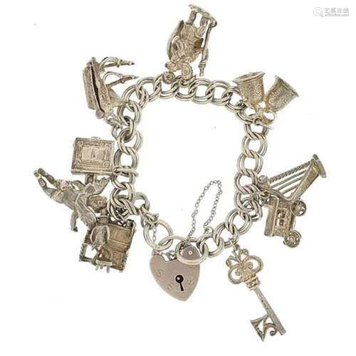 Silver charm bracelet with a selection of mostly silver char...