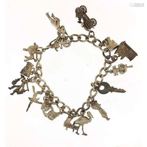 Silver charm bracelet with a selection of mostly silver char...