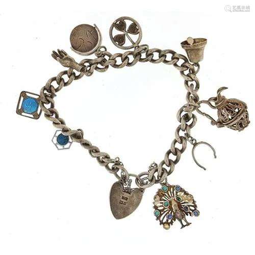 Silver charm bracelet with a selection of mostly silver char...