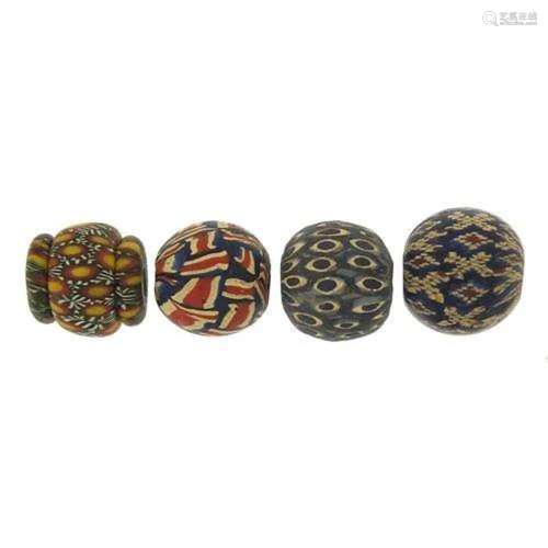 Four Islamic glass beads, each approximately 2cm high