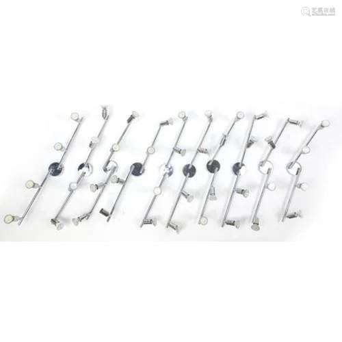 Nine contemporary adjustable chromed four branch wall lights...