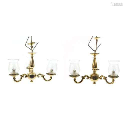 Pair of three branch chandeliers with glass shades, retailed...