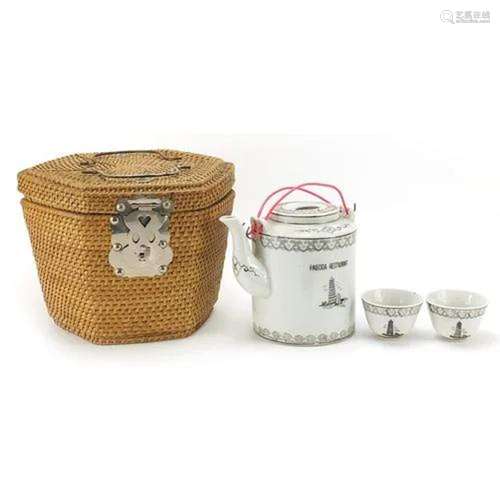 Chinese porcelain teapot and tea bowls housed in a wicker ca...