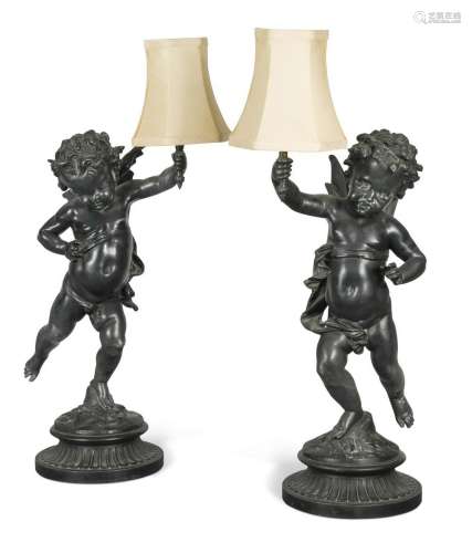 A pair of bronzed spelter cherubic table lamps, 20th century...