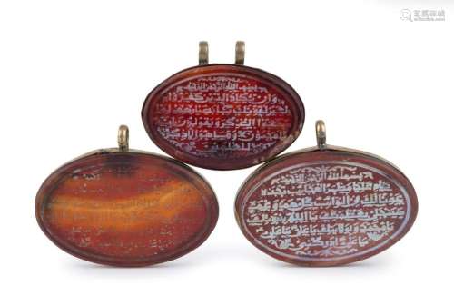 Three antique Ottoman agate pendants carved with passages of...