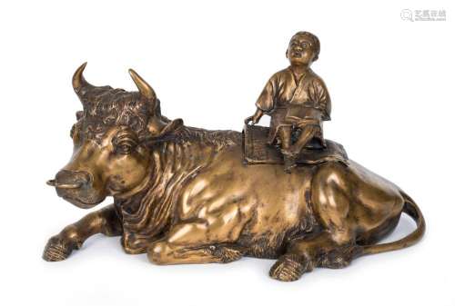 A Chinese cast bronze statue of a boy sitting on a recumbent...