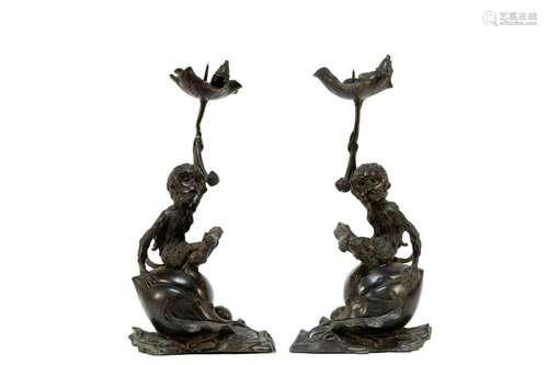 A pair of bronze monkey candle sticks