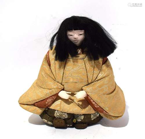 A Japanese Porcelain Seated Doll Wearing Brocade Robes, Show...