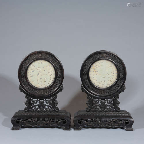 A pair of white jade disc and well-carved wood stand Qing dy...
