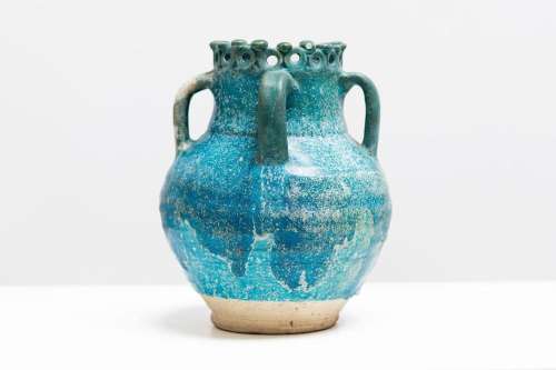 Islamic Art A turquoise glazed pottery vase with scalloped u...