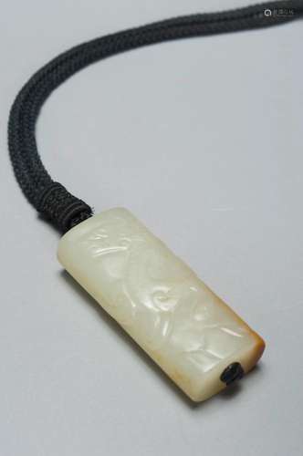 A WHITE AND RUSSET JADE DRAGON PENDANT QING DYNASTY, QIANLON...