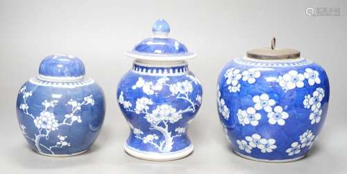 Three Chinese blue and white prunus decorated jars and cover...