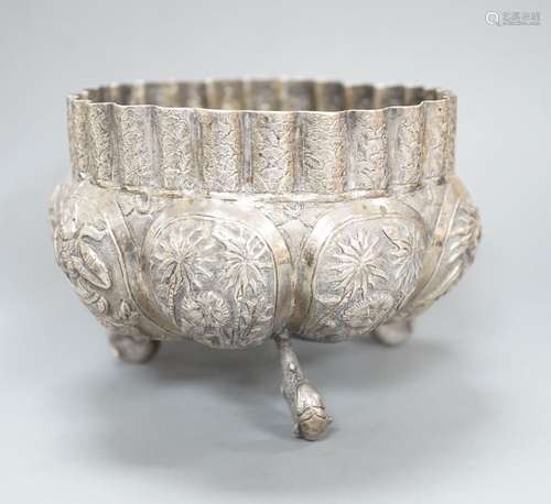 An Indian embossed white metal bowl, on three dolphin feet, ...