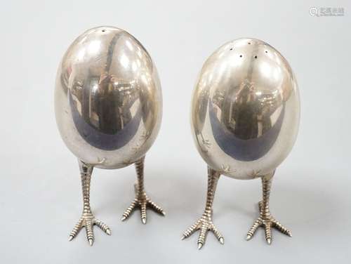 A pair of modern silver eggs on legs pepper and salt condime...