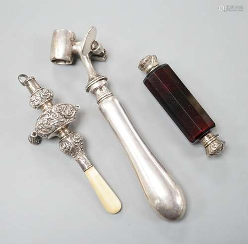 A silver mounted rattle, a white metal mounted double ended ...