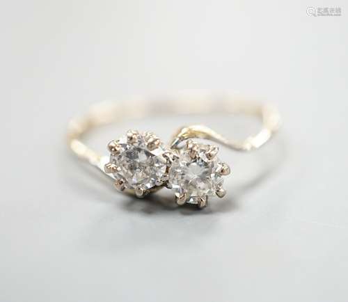 A yellow metal and two stone diamond set crossover ring, siz...