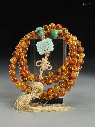 AN AMBER WITH JADEITE STRINGS OF BEADS