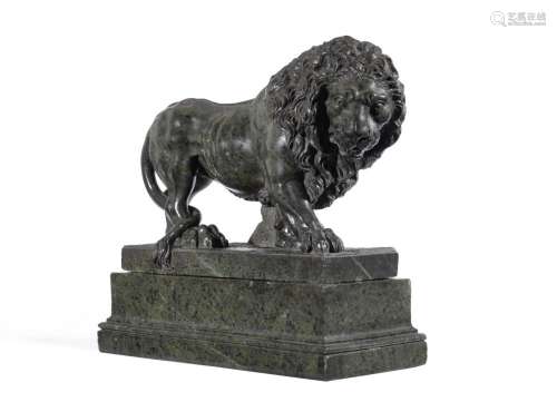 A GREEN SERPENTINE MARBLE FIGURE OF A PROWLING LION PROBABLY...