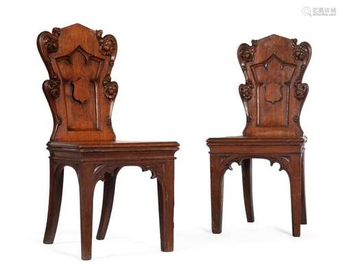 A PAIR OF VICTORIAN CARVED OAK HALL CHAIRS, IN GOTHIC REVIVA...