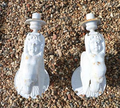 A pair of cast iron winged cherub wall lights