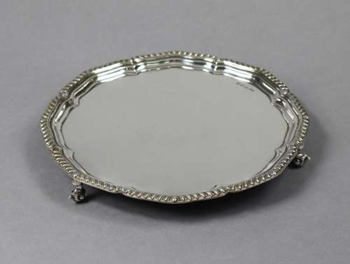 A silver circular salver with shaped raised border & gad...