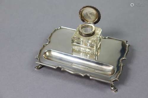 A George V silver desk inkstand with shaped border, pen-trou...