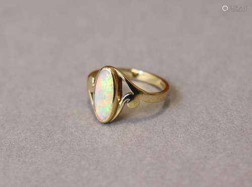 A 9ct. gold ring set elongated oval opal between open scroll...