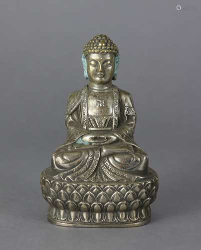 An oriental white metal figure of a Buddhistic deity, seated...