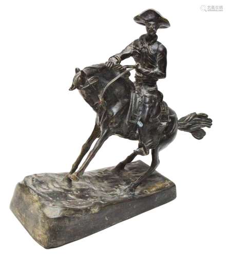 After Frederic Remington: a bronze cowboy on horseback,