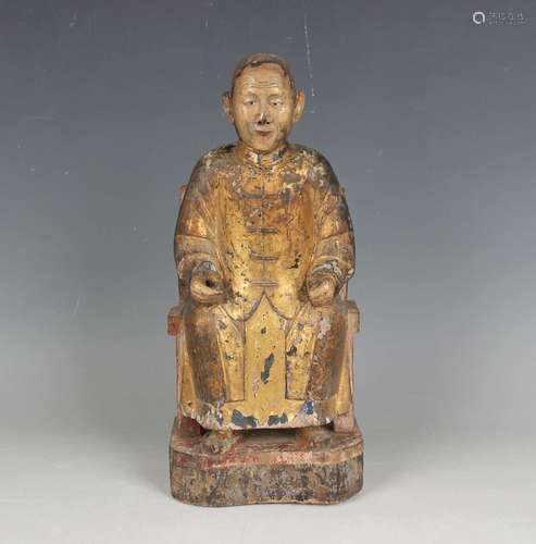 A Chinese carved giltwood figure, 18th century, the seated o...