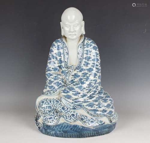 A Chinese blue and white porcelain figure of a seated monk, ...