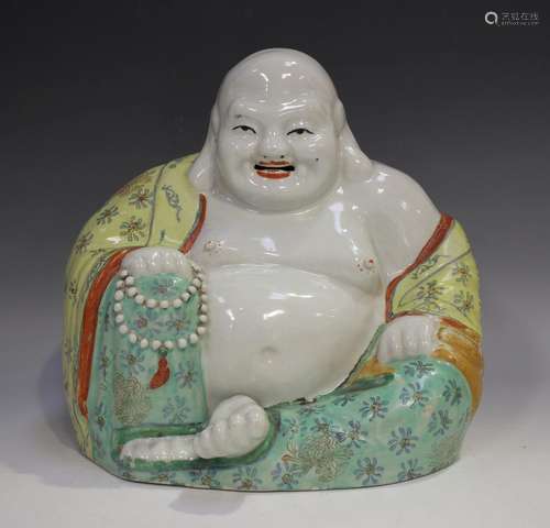 A Chinese porcelain figure of a seated smiling Buddha, early...