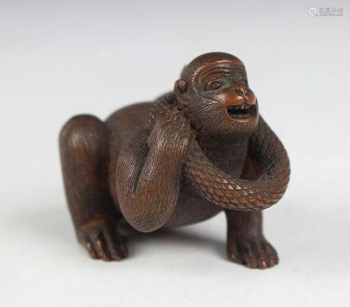 A Japanese wood okimono netsuke of a monkey and snake by Mas...