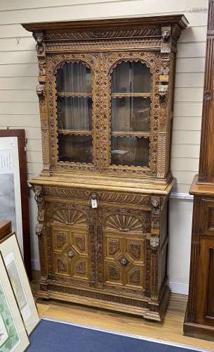 A late 19th century Flemish carved oak bookcase cupboard, wi...